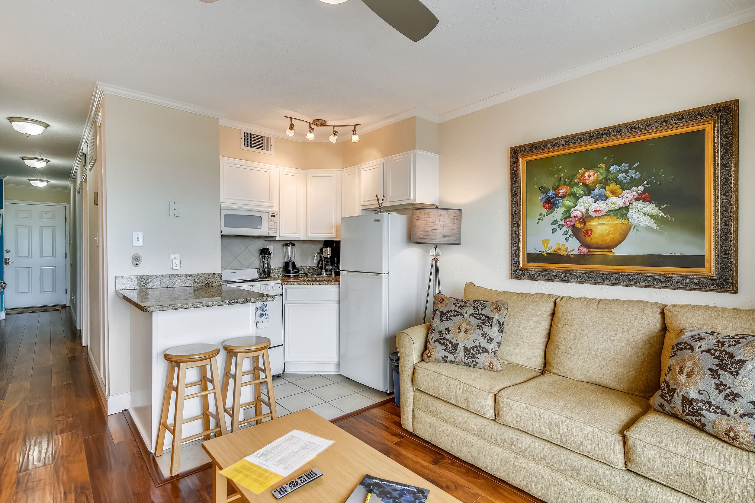 A compact living space with a kitchenette, a sofa set, and a dining area.