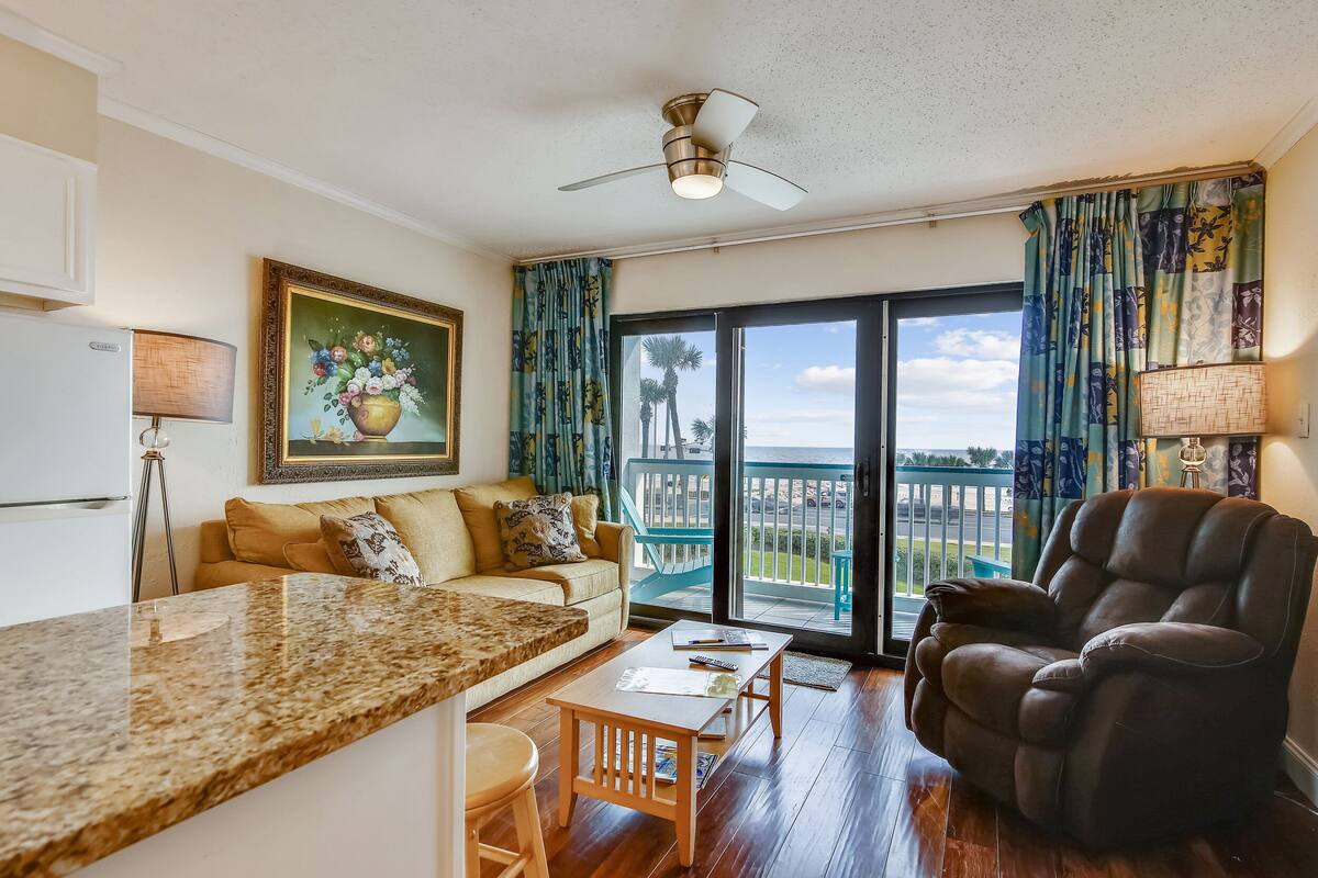 A living room with a sofa, a recliner, a coffee table, and a painting on the wall.