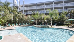 A swimming pool with lounge chairs and a building in the background. - Casa Del Mar by Ryson Vacation Rentals (Galveston)