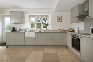A kitchen with a large island, built-in appliances, and a window with a view.