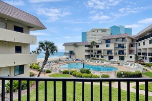 Un hotel con piscina, vistas a la playa y varios balcones.