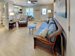A spacious living area with a sofa, chairs, and a dining table. - Harbor Lights Cottages #3 by Miss Kitty’s (Fulton)