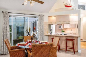 Cozy living space with a dining area and kitchenette, featuring a round table for four and a microwave, refrigerator, and countertop.