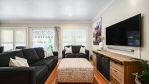 A living room with two sofas, a coffee table, a TV, and a wooden cabinet. - Beautiful spacious home a short walk to town centre. (Bright)