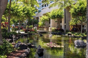 Escape to a serene oasis with a tranquil pond, lush greenery, and a charming wooden bridge.