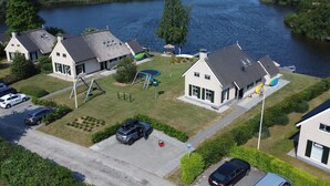 Un quartier résidentiel comprenant des maisons, une aire de jeux et un plan d’eau.