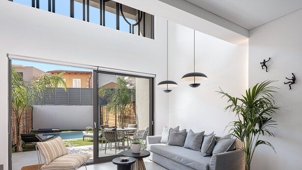 A modern living room with a grey sofa, striped armchairs, a coffee table, and a potted plant. - Urban Oasis - Walking distance to the Old Town, the beach and all kind of shops! (Chania)