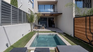 A modern outdoor pool area with a rectangular pool, lounge chairs, and a dining table. - Urban Oasis - Walking distance to the Old Town, the beach and all kind of shops! (Chania)