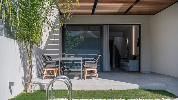 A modern outdoor patio with a pool, a dining area with wicker furniture, and a staircase leading to an interior space. - Urban Oasis - Walking distance to the Old Town, the beach and all kind of shops! (Chania)