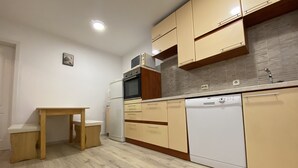Une cuisine moderne avec des meubles en bois, un four encastré et un lave-vaisselle.