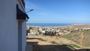 A coastal town with buildings and a beach in the background. - Casa Morisca Classic (Sidi Ifni)