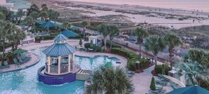 Relax by the pool surrounded by lounge chairs and umbrellas, overlooking the beach and dunes.