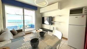 A modern kitchen with a built-in oven, a refrigerator, and a flat-screen TV.