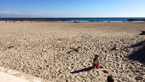 A wide sandy beach with a clear blue sky.