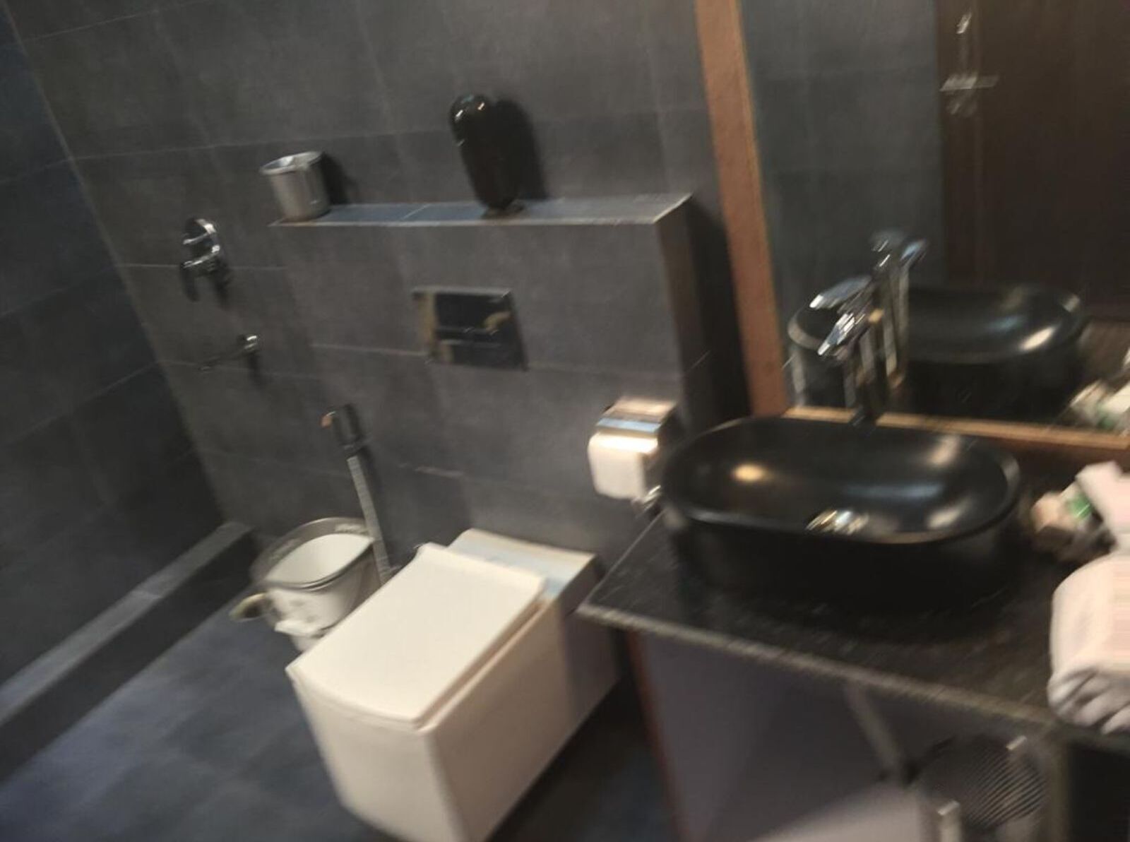 Une salle de bain moderne avec des toilettes, un lavabo et un miroir.