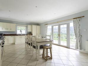 Enjoy cooking in this kitchen with a large island and seating, a tiled floor, and a window offering a view of the outdoors.
