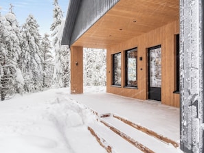 A modern building with a wooden exterior, large windows, and a snowy landscape.