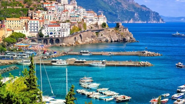 A coastal town with colorful buildings, a marina with boats, and a mountainous backdrop. - Raphael House, terrace with solarium and sea view (Conca dei Marini)