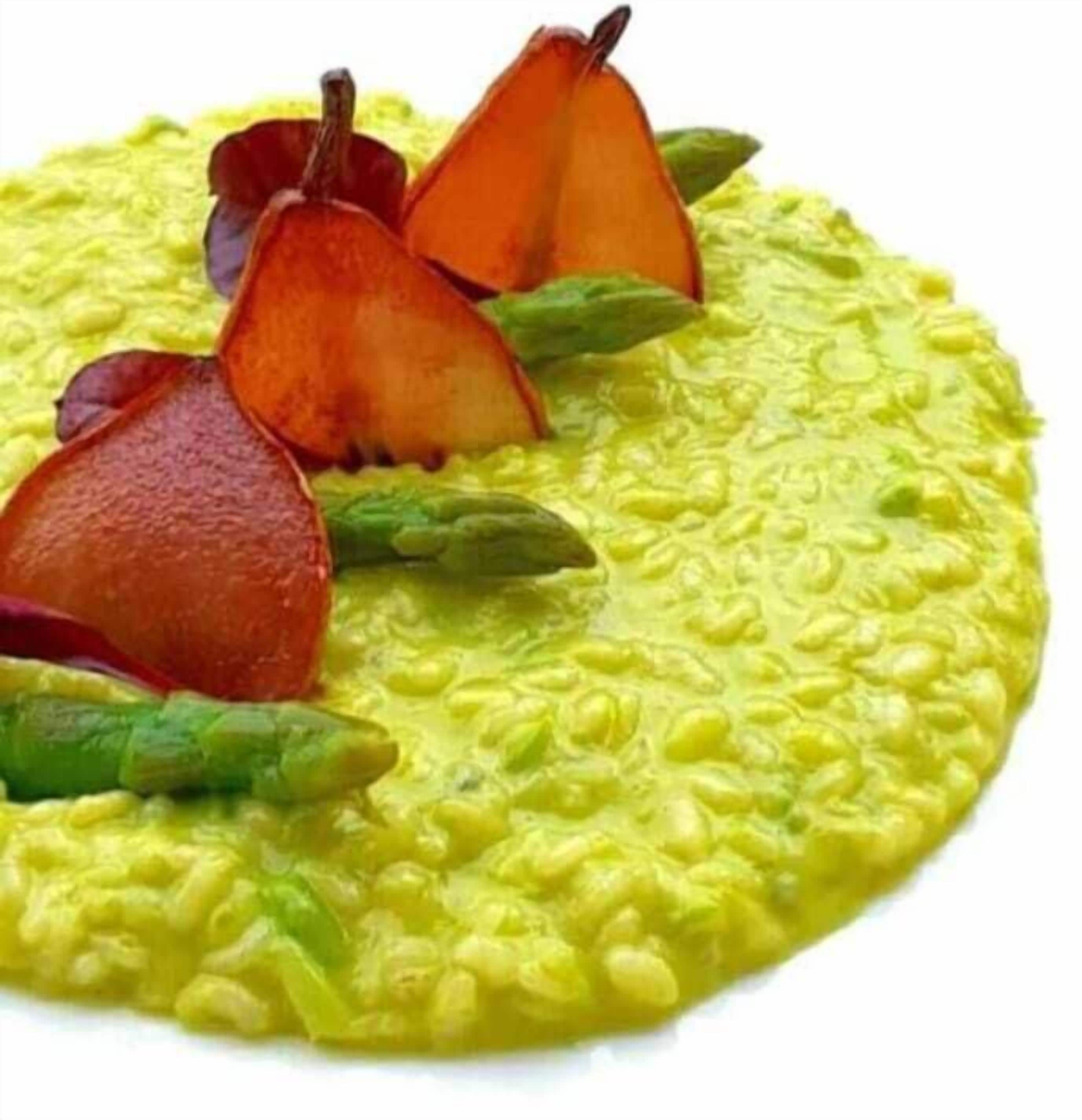 Un plato con base amarilla, espárragos verdes y láminas de pera roja.