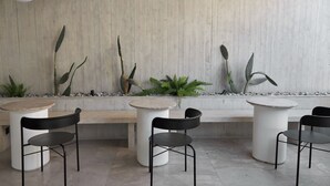 Un interior moderno con pared de concreto, muebles minimalistas y plantas en macetas.