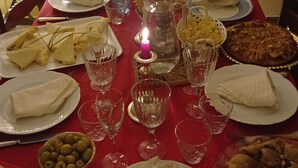 A dining table set with plates, glasses, and a candle. - Spacious apartment with a view in the center of Montepulciano, Tuscany, Siena  (Montepulciano)