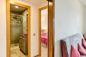 Une chambre à coucher avec un lit, une table de chevet, un miroir et une armoire.
