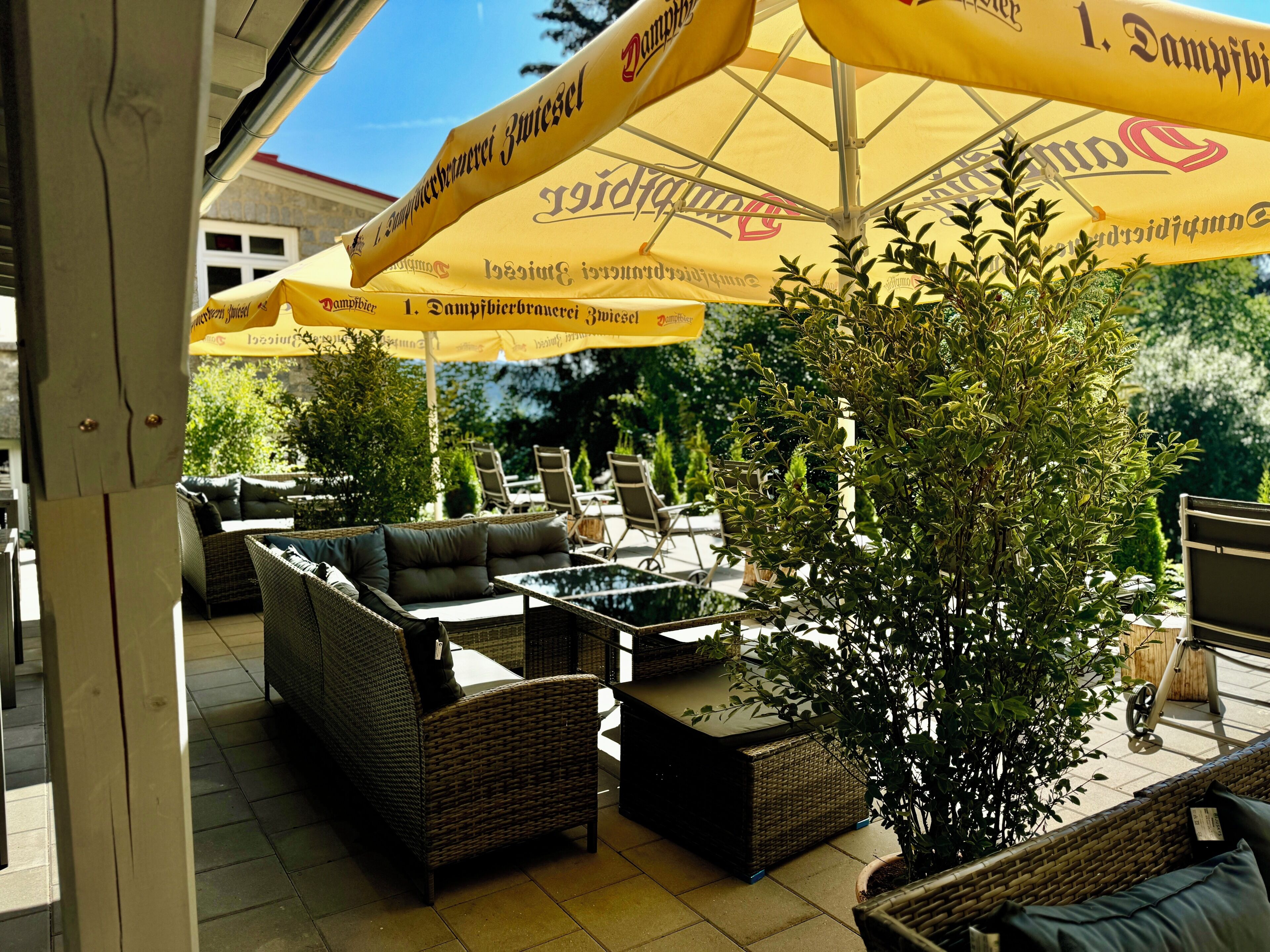 An outdoor seating area with wicker furniture and yellow umbrellas.