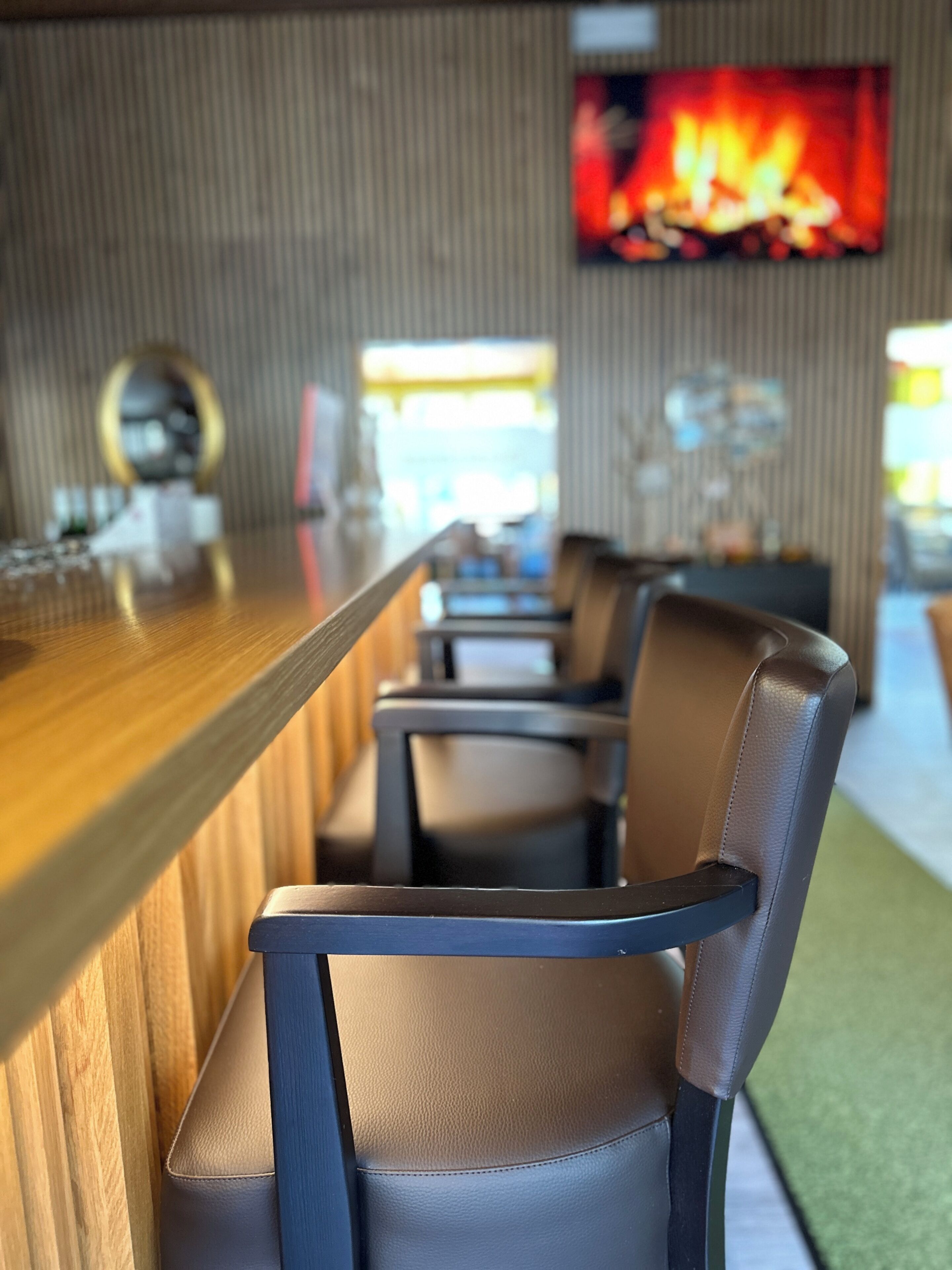 A bar area with a long counter and several chairs.