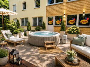 Un área de spa con un jacuzzi, sillones de descanso y plantas en macetas.