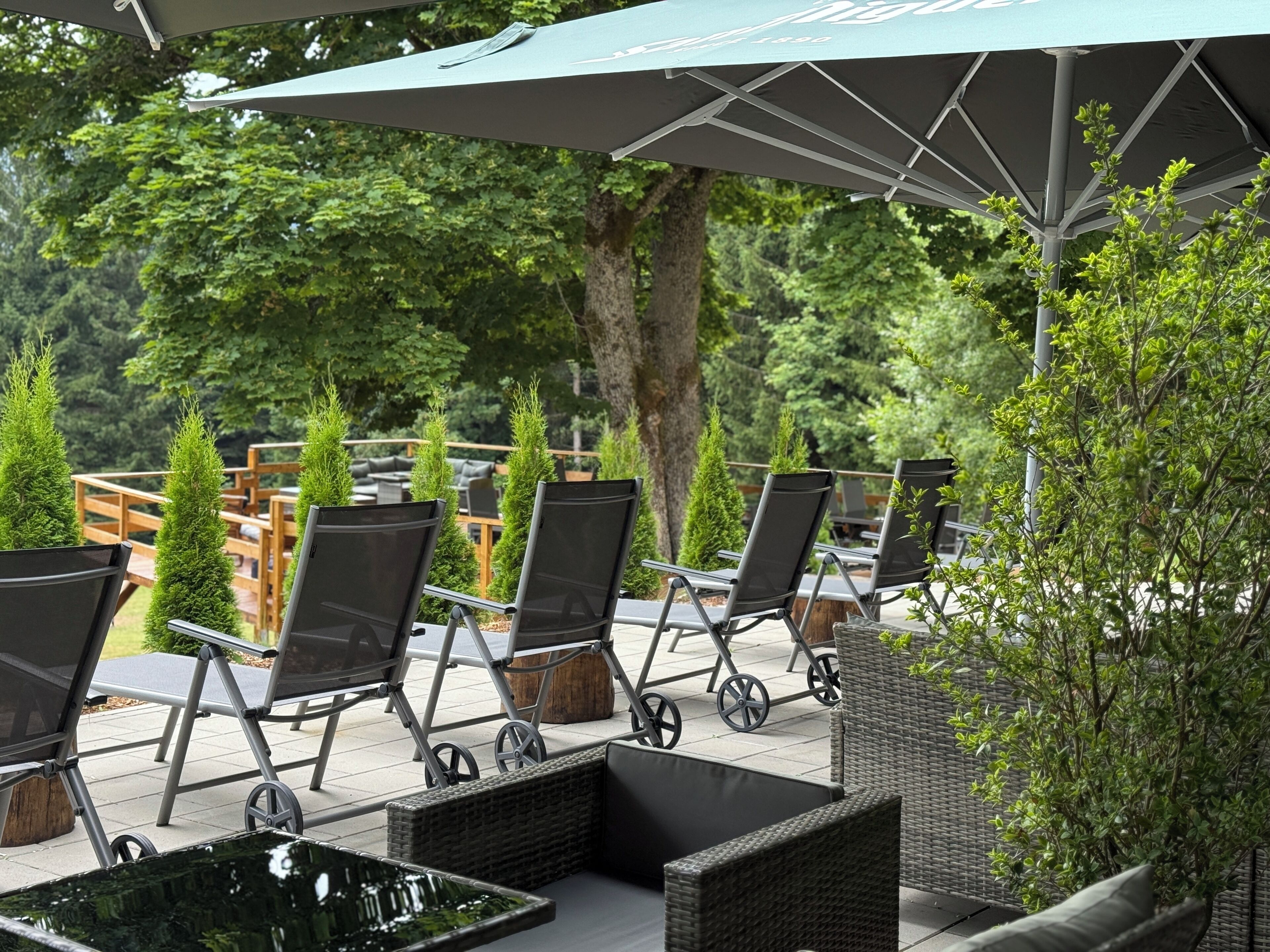 Outdoor seating with chairs and tables, a small water feature, and a pergola with umbrellas.