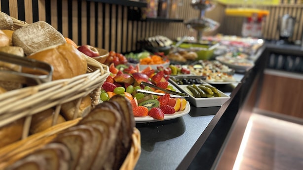Un bufé con diversos alimentos, incluyendo pan, frutas y verduras.