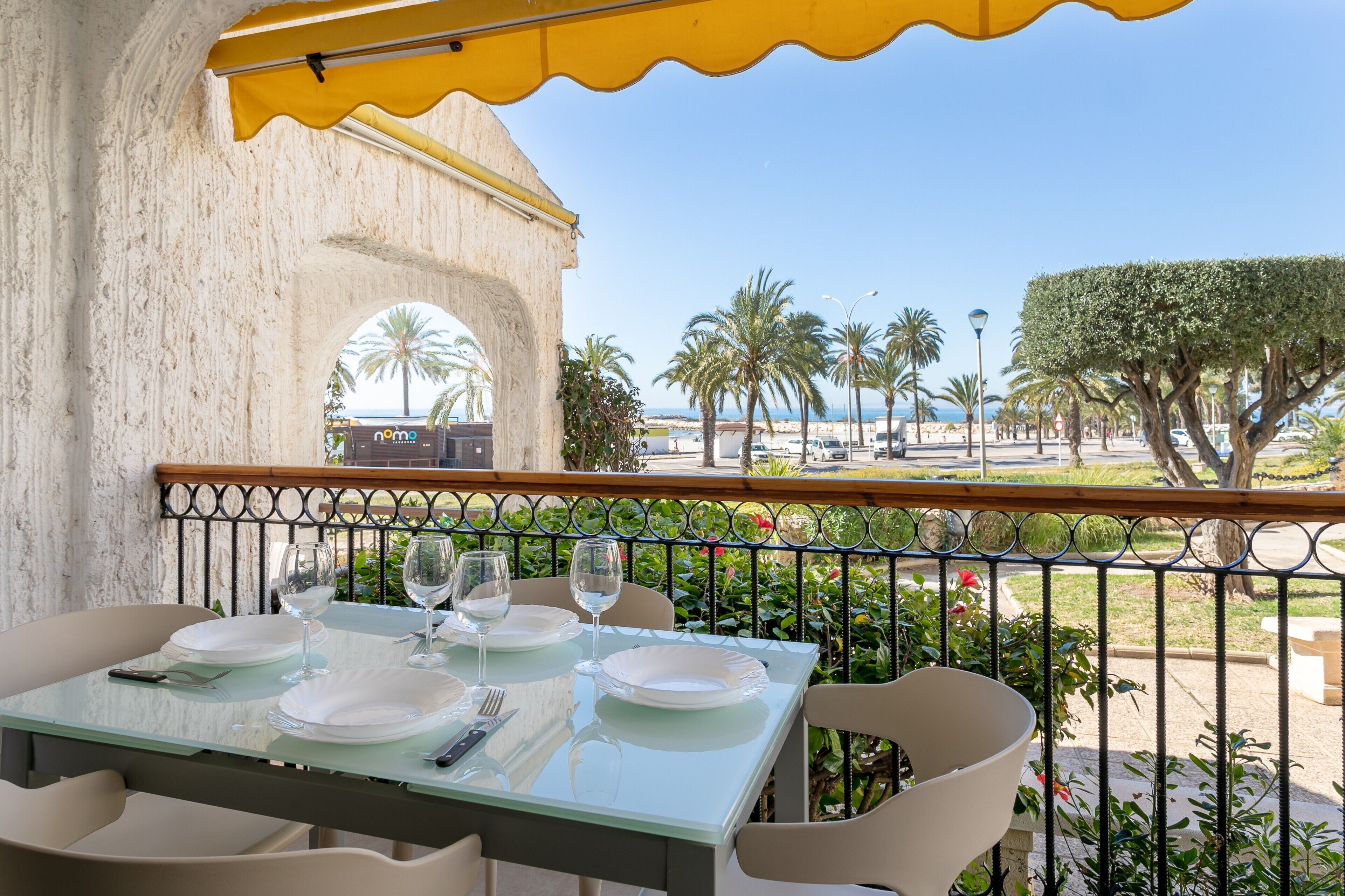 A table set for dining with a view of palm trees and a building in the background.