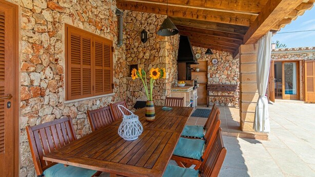 A stone wall exterior, wooden dining table, and a stone fireplace. - Villa 'Hortet' with Private Pool, Wi-Fi and Air Conditioning (Campos)