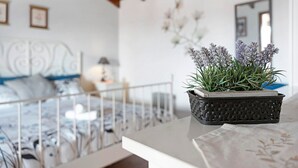 Ein Schlafzimmer mit einem Bett, einem Nachttisch und einer Topfpflanze auf einem Tisch.