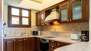 Una cocina con armarios de madera, microondas, tostadora y cafetera.