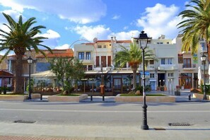 Una calle con edificios, palmeras y un farol.