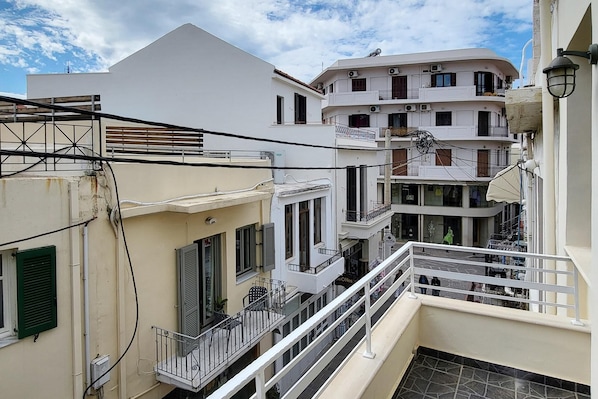 Un edificio de varios pisos con balcones, una escalera y vistas a la calle.