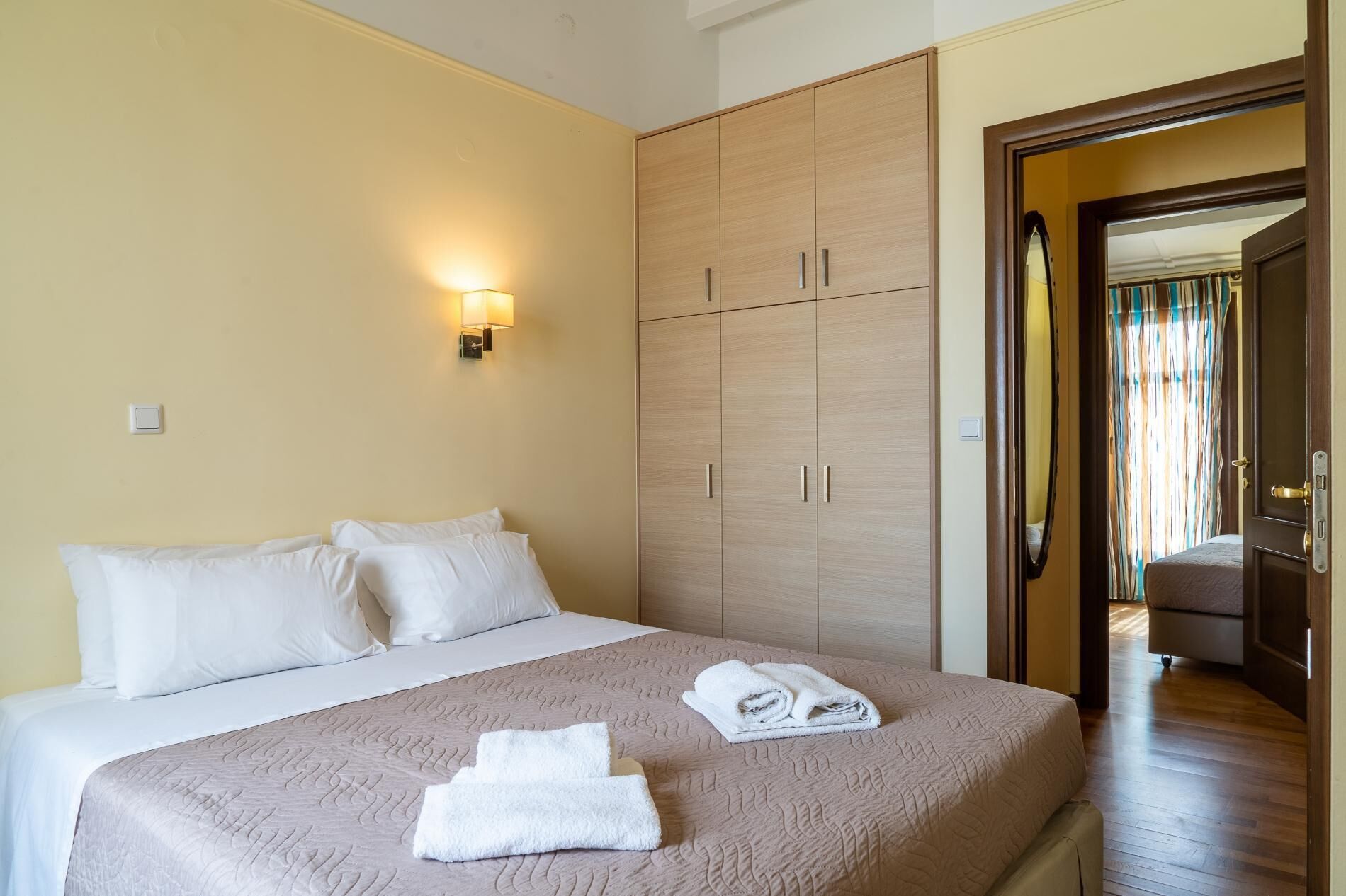 Una habitación de hotel con una cama, un armario y un baño visible a través de una puerta abierta.