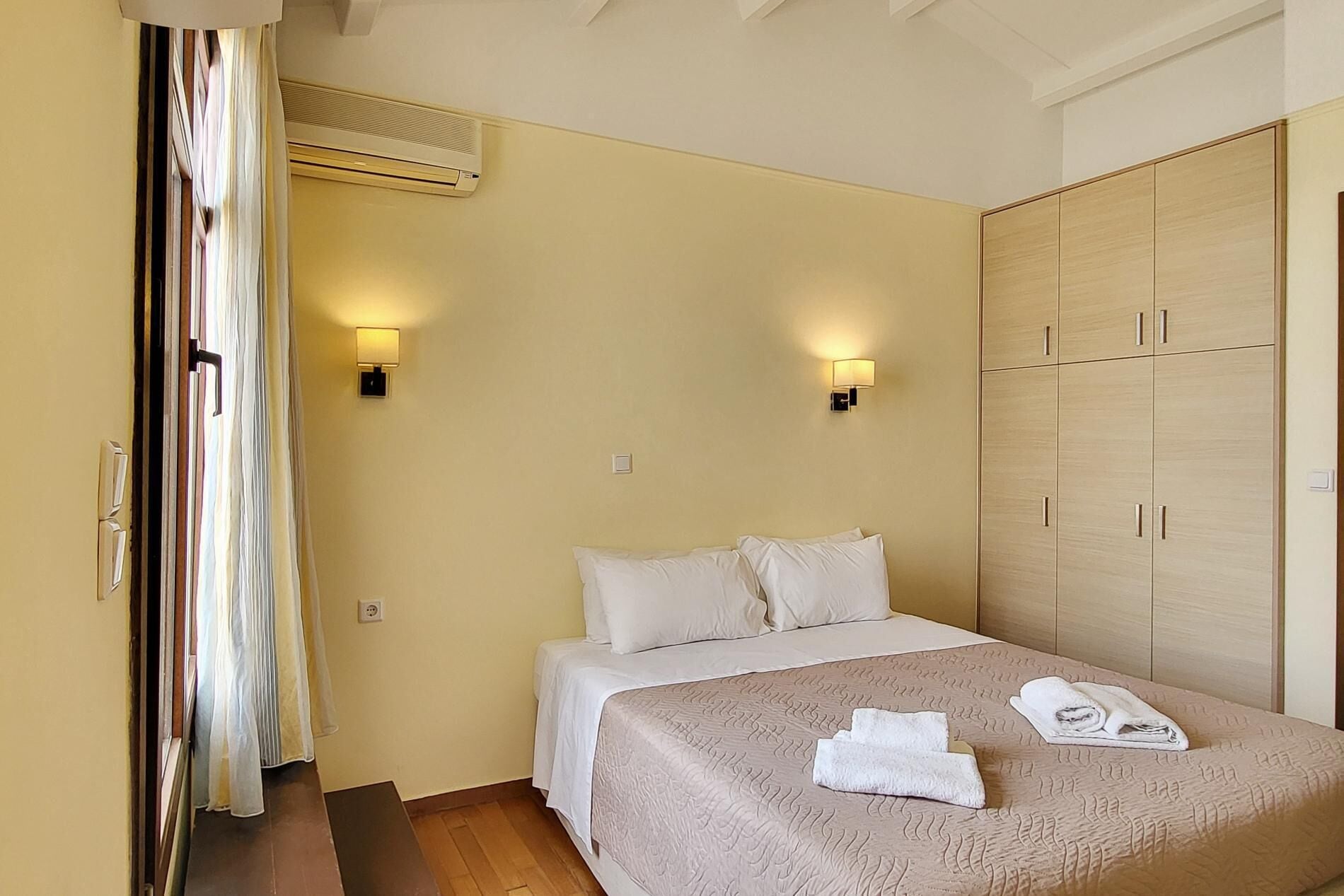 Ein Hotelzimmer mit einem Bett, einem Kleiderschrank und zwei Wandleuchten.
