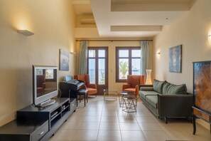 Una sala de estar con televisor, piano y zona de asientos.