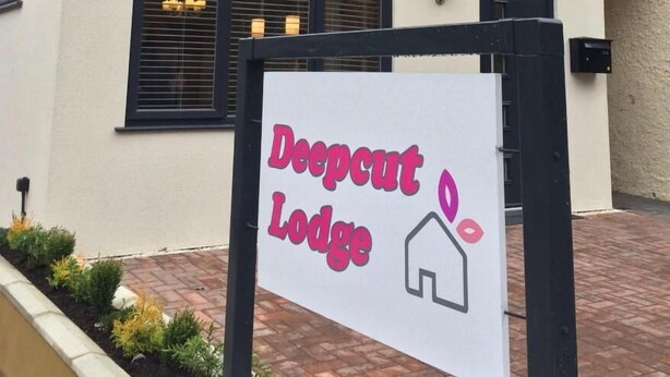 Un letrero para Deepcut Lodge con un icono de casa.