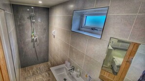 Un baño moderno con ducha, lavabo y ventana.