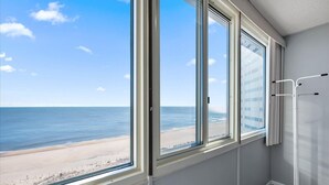 A room with a large window overlooking a beach and ocean. - Quay-3 Bedroom Ocean Front Condo (Ocean City)