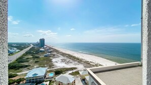 A coastal view with a beach, a road, and buildings including a tall hotel. - Oasis, formerly Phoenix West II 4BR!!  New Adult Pool,  Lazy River/Slide!! (Orange Beach)