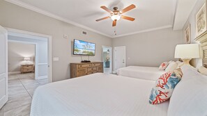 A bedroom with two beds, a ceiling fan, a TV, and a dresser. - Oasis, formerly Phoenix West II 4BR!!  New Adult Pool,  Lazy River/Slide!! (Orange Beach)
