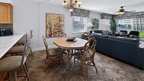 A modern kitchen with a dining table, chairs, and a microwave.