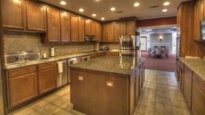 A spacious kitchen with wooden cabinets, granite countertops, stainless steel appliances, and recessed ceiling lights. - 110 El Matador 2 Bedroom Condo by RedAwning (Fort Walton Beach)