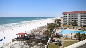 A beach view with a pool and a building.
