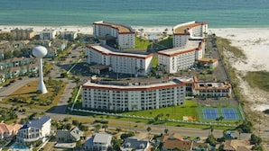 A coastal hotel complex with multiple buildings, a large white tower, and a beach in the background. - 335 El Matador 1 Bedroom Condo by RedAwning (Fort Walton Beach)
