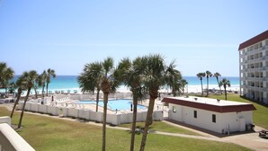 A hotel with a pool, palm trees, and a view of the beach. - 338 El Matador 2 Bedroom Condo by RedAwning (Fort Walton Beach)